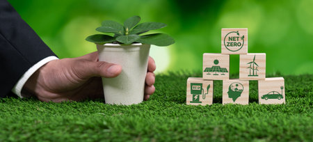 Businessman holding plant pot with Net zero cube symbol. Forest regeneration and reducing CO2 emission for natural awareness. Ethical green business with eco-friendly policy grow forest concept. Alterの写真素材