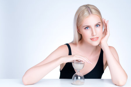 Personable model hold hourglass in aging young beauty concept of anti-aging skincare treatment for...