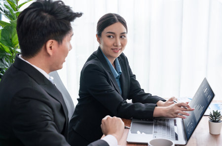 Busy analyst team in office discuss data analysis and marketing strategy using BI dashboard and statistics on laptop screen to improve business performance at meeting with strong teamwork. Jubilantの写真素材