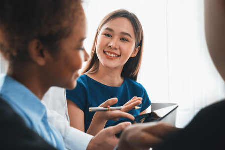 Happy diverse business people work together, discussing in corporate office. Professional and diversity teamwork discuss business plan on desk with laptop. Modern multicultural office worker. Concordの写真素材
