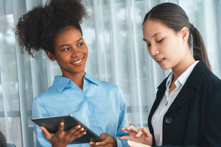 Happy diverse business people work together, discussing in corporate office with tablet. Professional and diversity teamwork discuss business plan. Modern multicultural office worker. Concordの写真素材