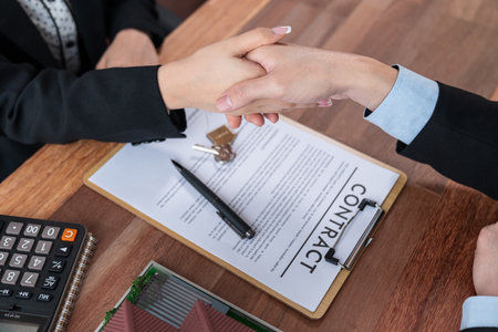 House loan agreement was successfully finalized with handshake. Buyers and real estate agents are...