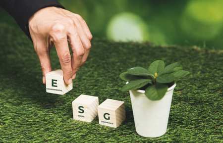 Businessman holding plant pot with ESG cube symbol. Forest regeneration and natural awareness. Ethical green business with eco-friendly policy utilizing renewable energy to preserve ecology. Alterの写真素材