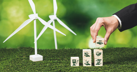 Businessman putting Net Zero symbol cube on stack top for corporate use eco-friendly energy and sustainability. Wind turbine generate renewable and clean energy with net zero CO2 emission. Alterの写真素材