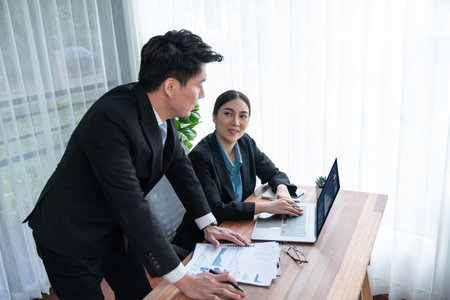 Busy analyst team in office discuss data analysis and marketing strategy using BI dashboard and statistics on laptop screen to improve business performance at meeting with strong teamwork. Jubilantの写真素材