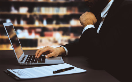 Businessman focused on his laptop working on financial report or planning business strategy in...