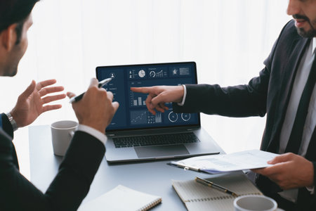 Busy analyst team discussing financial data on digital dashboard, analyzing chart and graph using data science software display on a laptop screen. Business intelligence and Fintech. Ferventの写真素材