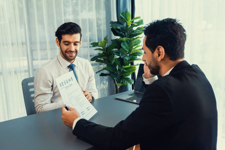 Interviewing job applicant in office with resume paper. Candidate wear suit for formal conversation with interviewer. Recruitment process with question about career and work experience. Ferventの写真素材