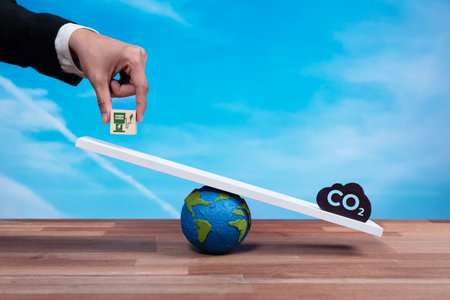 Businessman weighs EV charging station on scale against CO2 symbol, promoting corporate...