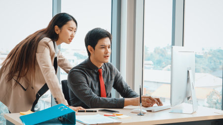 Two business people talk project strategy at office meeting room. Businessman discuss project planning with colleague at modern workplace while having conversation and advice on financial report. Jivyの写真素材