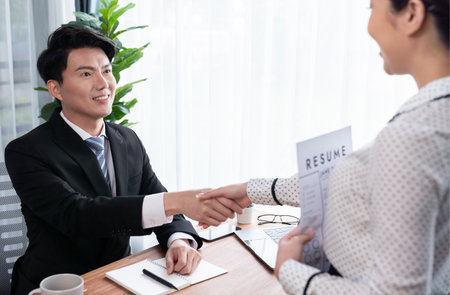 Happy business people shake hands after successful meeting or job interview with resume. HR manager reach hand with congratulatory handshake to job applicant welcoming new employee. Jubilantの写真素材