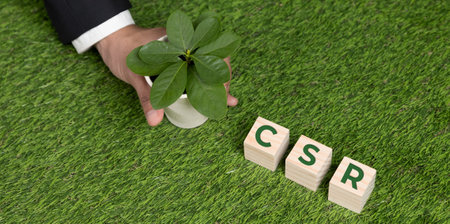 Top view businessman holding plant pot with cube symbolizing CSR. Ethical and eco-friendly green business with no CO2 emission policy. Commit to corporate social responsible for green community. Alterの写真素材