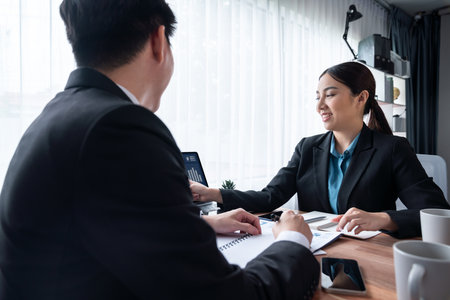 Busy analyst team in office discuss data analysis and marketing strategy using BI dashboard and statistics on laptop screen to improve business performance at meeting with strong teamwork. Jubilantの写真素材