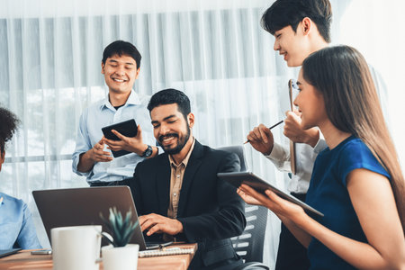 Happy diverse business people work together, discussing in corporate office. Professional and diversity teamwork discuss business plan on desk with laptop. Modern multicultural office worker. Concordの写真素材