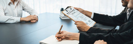 Candidate and interviewers discuss work experience and qualifications in friendly job interview at corporate office. HR team evaluates job application while interviewee explaining profile. Prodigyの写真素材