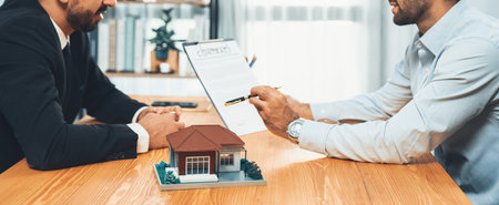 Client review loan contract with real estate agent, discussing term, interest and property ownership. Analyzing legal document, reading agreement before deciding. Real estate transaction. Ferventの写真素材