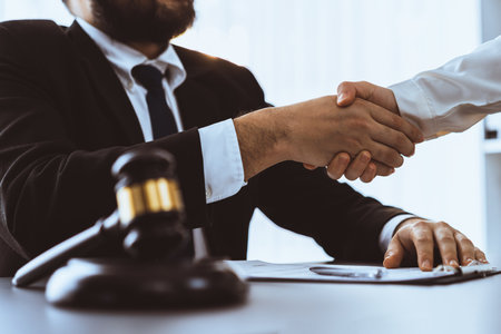 Closeup lawyer or attorneys colleagues handshake after successful legal discussing on contract agreement for lawsuit to advocate resolves dispute in court ensuring trustworthy partner. Equilibriumの写真素材