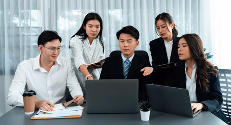 Harmony in office concept as business people analyzing dashboard paper together in workplace. Young colleagues give ideas at manager desk for discussion or strategy planning about project.の写真素材