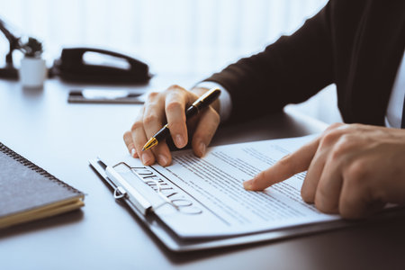 Businessman signs contract agreement paper or business legal form with trust and professionalism. Closeup of hand holding pen in corporate meeting for official business deal. Equilibriumの写真素材