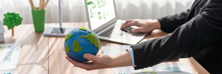 Businessman or CEO of the green corporate company holding paper Earth as concept for environmental...