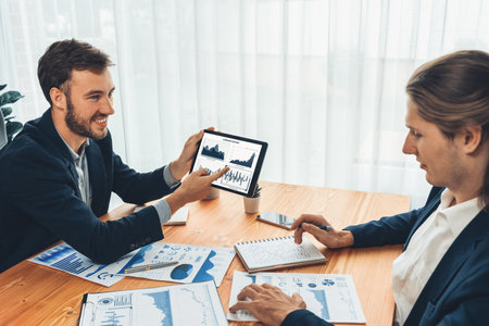 Busy analyst team in office analyzing financial data analysis for marketing strategy in workspace using BI dashboard with graph and chart on tablet screen to improve business performance. Entityの写真素材