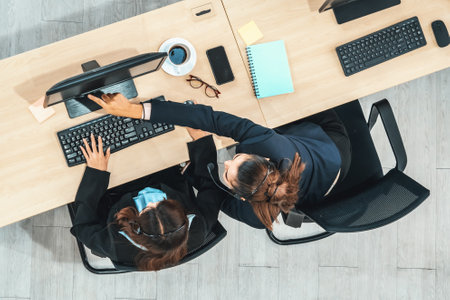 Business people wearing headset shot from top view in office working with computer. Jivyの写真素材