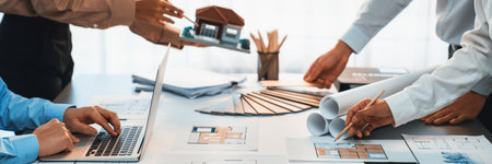 Group of interior designer team in meeting, discussing with engineer on interior design and planning for house project blueprint and model, choosing color sample and mood board materials. Insightの写真素材