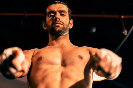 Boxing fighter shirtless posing, caucasian boxer punch his bare fist and wrap in front of camera,...