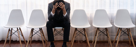 Foto de Nervous and panic job applicant with stressful emotion on job interview while he sitting and waiting for his turn. Sad businessman holding his head with hands after making mistake. Trailblazing - Imagen libre de derechos