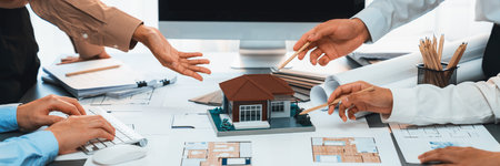 Group of interior designer team in meeting, discussing with engineer on interior design and planning for house project blueprint and model, choosing color sample and mood board materials. Insightの写真素材