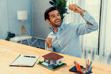 Happy real estate agent closes a deal with buyer, selling house and celebrating with excitement. Successful business sale met with celebratory gesture and expression of satisfaction. Ferventの写真素材
