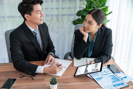 Busy analyst team in office discuss data analysis and marketing strategy using BI dashboard and statistics display on tablet screen to improve business performance at meeting with teamwork. Jubilantの写真素材