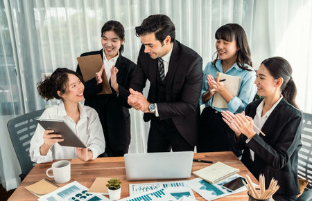 Diverse group of business analyst team analyzing financial data report paper on office table. Chart and graph dashboard by business intelligence analysis for strategic marketing planning Habilimentの写真素材