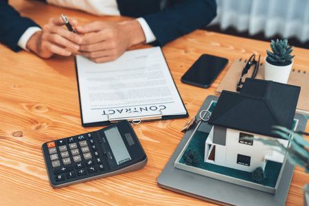 Real estate agent calculating tax and interest, insurance agreement terms with client buying property and applying for house loanの写真素材