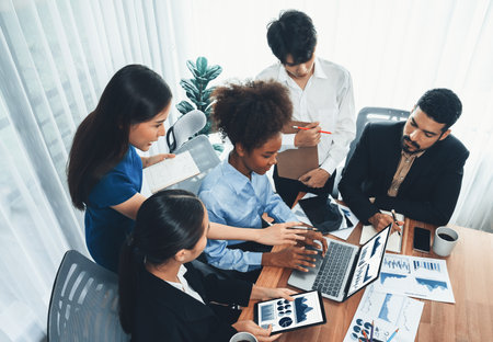 Multiracial analyst team use BI Fintech software to analyze financial data on meeting table. Financial dashboard data display on laptop screen with analyzed chart for marketing indication. Concordの写真素材