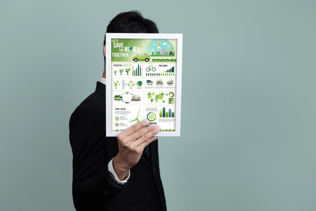 Businessman holding paper promoting corporate environmental policy with sustainable eco-friendly idea of recycle, renewable clean energy and forest growth. Go green and save earth concept. Alterの写真素材
