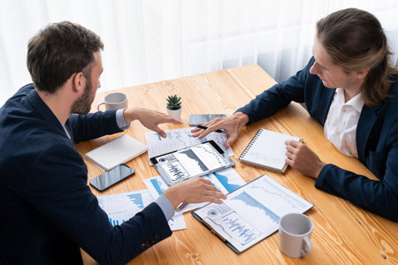 Busy analyst team in office analyzing financial data analysis for marketing strategy in workspace using BI dashboard with graph and chart on tablet screen to improve business performance. Entityの写真素材