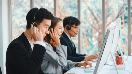 Business people wearing headset working in office to support remote customer or colleague. Call center, telemarketing, customer support agent provide service on telephone video conference call. Jivyの写真素材