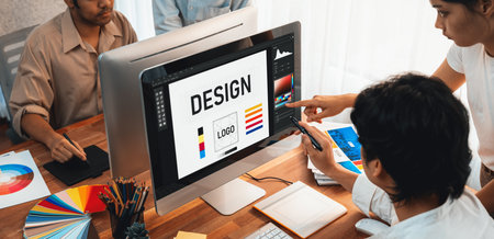 Graphic designer work on computer laptop and with graphic drawing pen while brainstorming unique design with professional graphic team in modern digital studio workplace. Panorama shot. Scrutinizeの写真素材