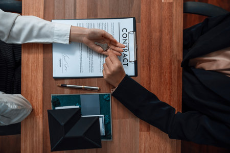 Successful house loan agreement sealed with a top view handshake. Buyers and agents celebrate the home ownership of property with a sense of accomplishment and satisfaction. Enthusiasticの写真素材