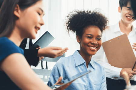 Young african businesswoman working together and discussing in corporate office with multicultural coworkers. Professional and diversity teamwork discuss business plan on desk. Concordの写真素材