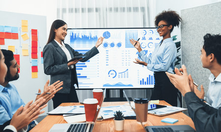 Business people celebrate after successful presentation or meeting on data analysis display on TV...
