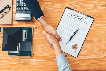 Finalize house loan agreement with top view handshake, buyer and real estate agent celebrate accomplishment of home ownership with sense of satisfaction. New home owner shake hand with broker. Entityの写真素材