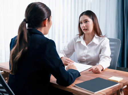 Business deal meeting, young businesswomen carefully reviewing terms and condition of contract agreement papers in office. Corporate lawyer give consultation on contract deal. Enthusiasticの写真素材