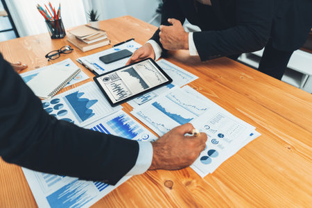 Closeup busy analyst team discussing financial data on digital dashboard, analyzing chart and graph using data science software display on a laptop screen. Business intelligence and Fintech. Ferventの写真素材