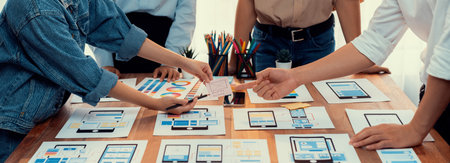 Panorama shot of front-end developer team brainstorming UI and UX designs for mobile app on paper wireframe interface. User interface development team planning for user-friendly UI design. Scrutinizeの写真素材