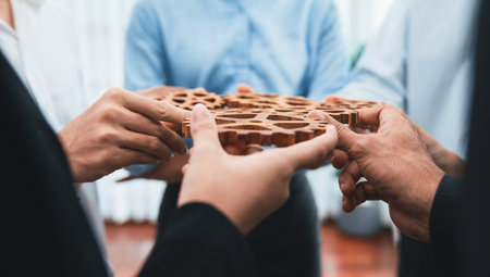 Office worker holding cog wheel as unity and teamwork in corporate workplace concept. Diverse colleague business people showing symbol of visionary system and mechanism for business success. Concordの写真素材