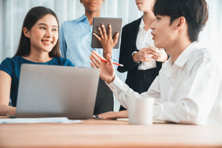 Happy diverse business people work together, discussing in corporate office. Professional and diversity teamwork discuss business plan on desk with laptop. Modern multicultural office worker. Concordの写真素材