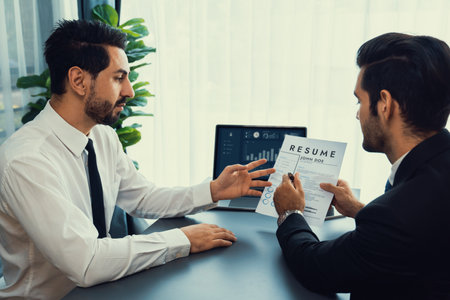 Interviewing job applicant in office with resume paper. Candidate wear suit for formal conversation with interviewer. Recruitment process with question about career and work experience. Ferventの写真素材