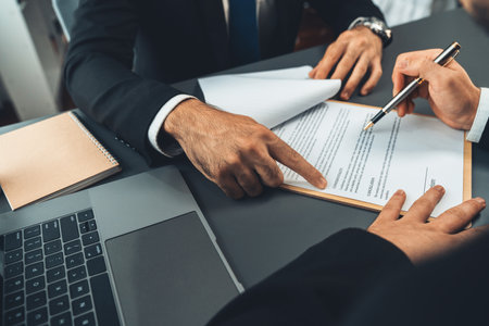 Closeup hand signing contract document with pen, sealing business deal with signature. Businesspeople finalizing business agreement by writing down signature on contract paper. Ferventの写真素材